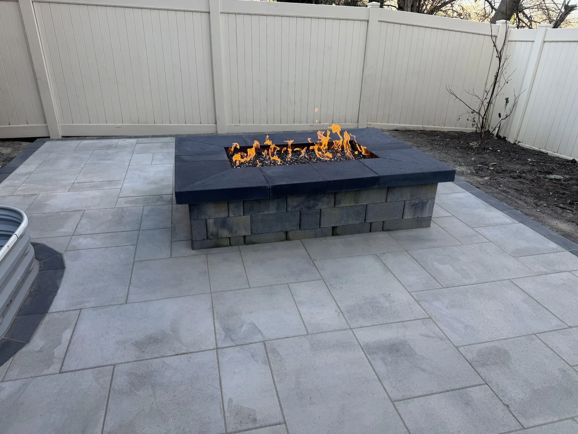 Low linear block fire feature on a paver patio