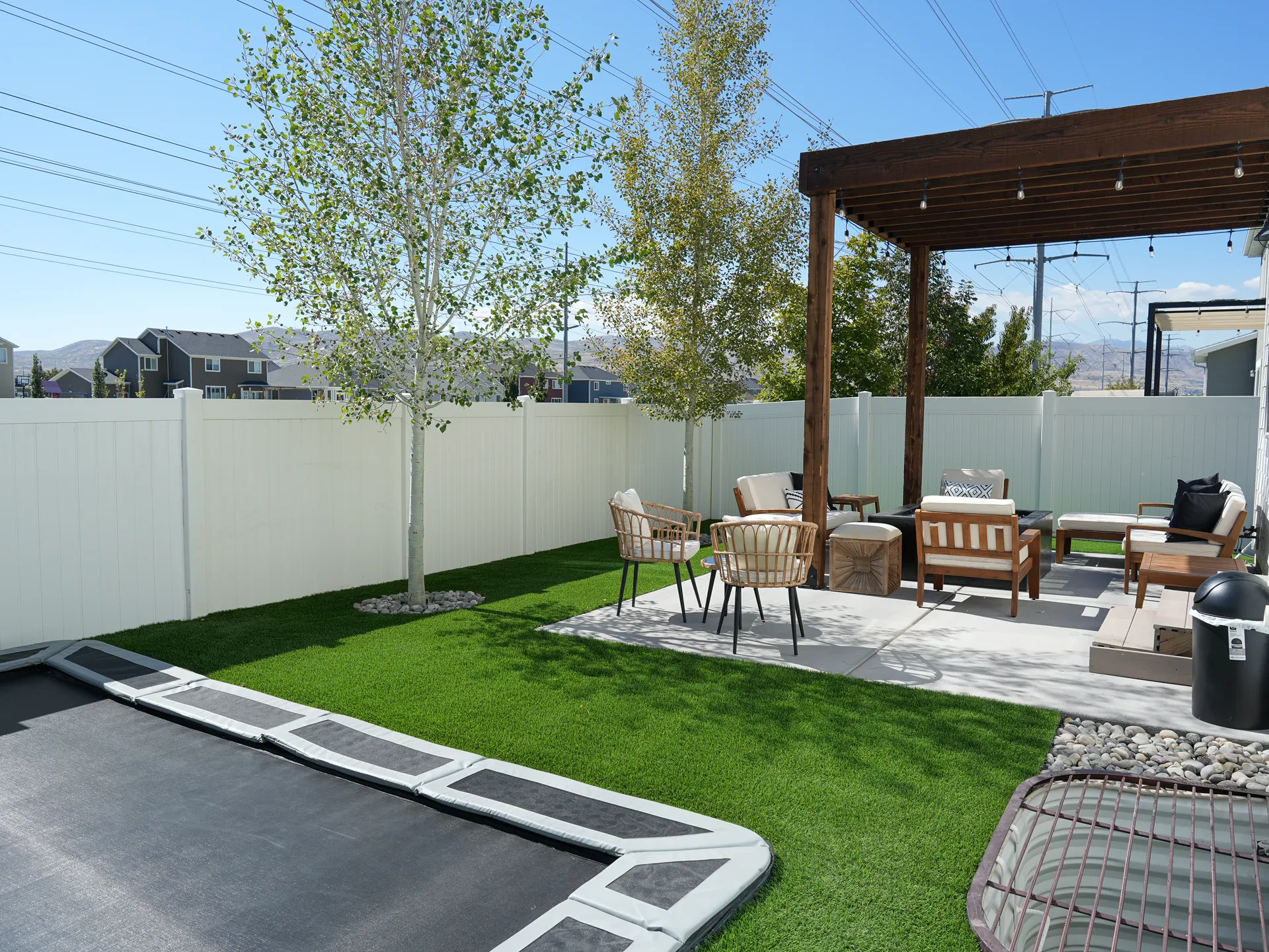 Artificial turf, wood pergola, custom concrete patio and in-ground trampoline in Bluffdale, Utah.