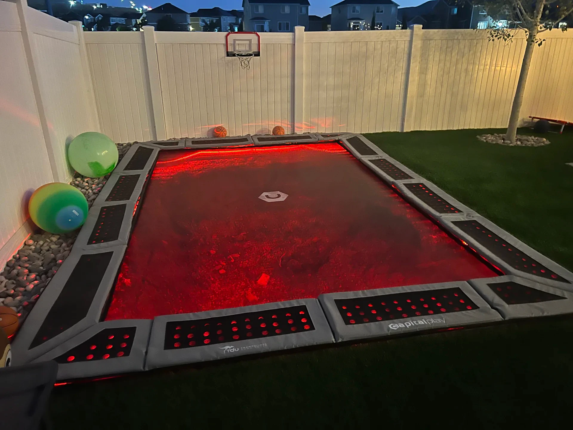 Illuminated in-ground trampoline with integrated red perimeter lighting in Bluffdale, Utah.