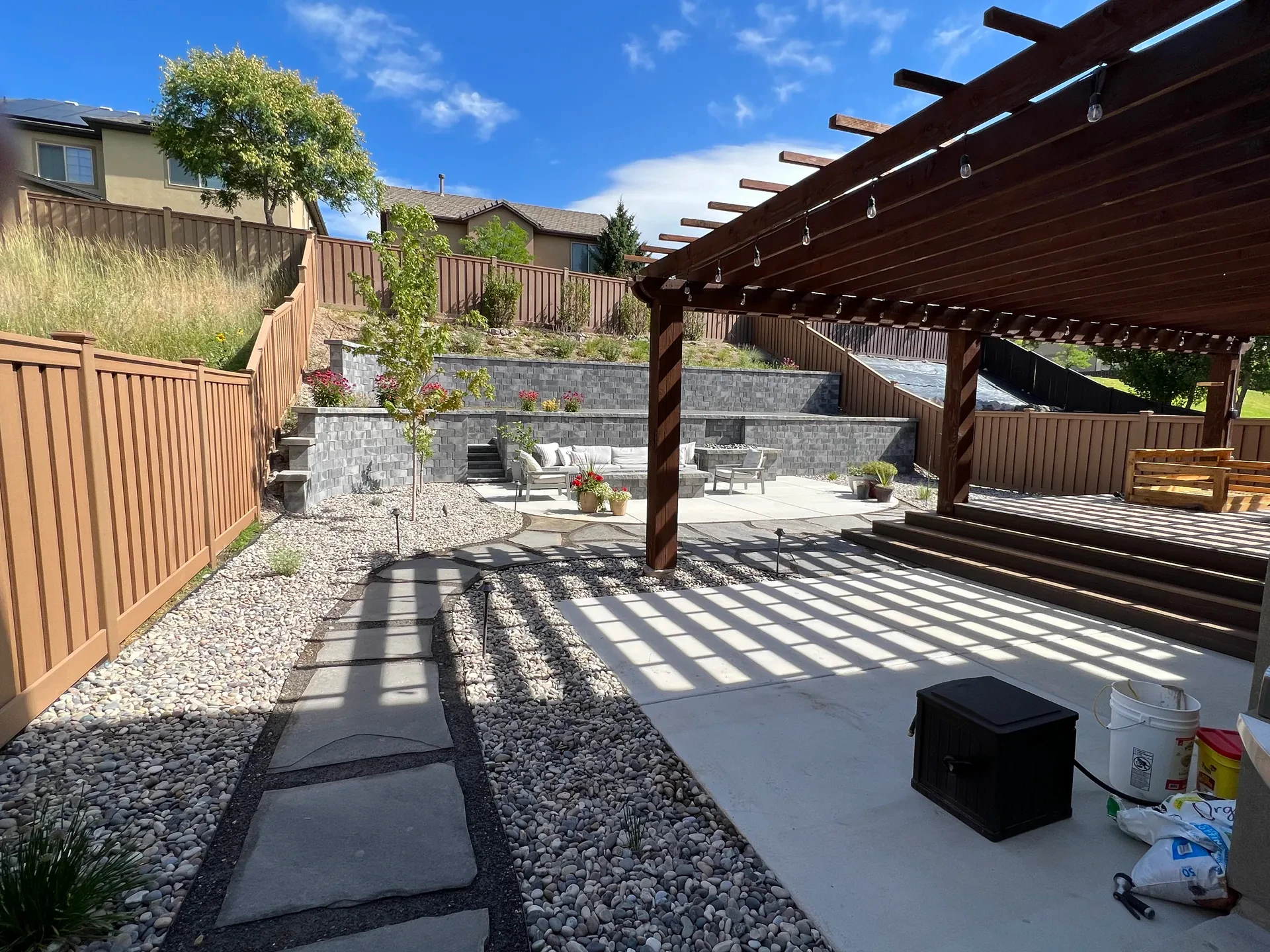 Completed Draper outdoor living retreat — pergola, retaining walls, and patio overview