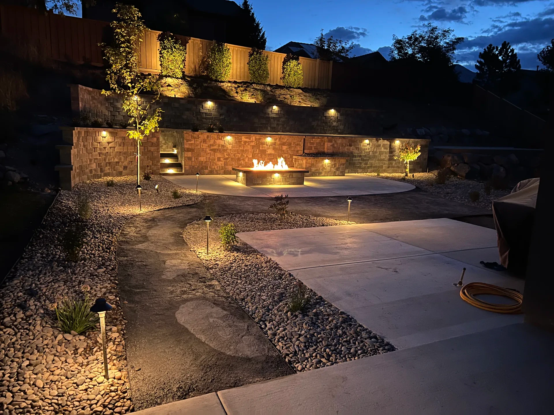 Landscape lighting on fire feature and Belgard retaining walls in Draper, Utah