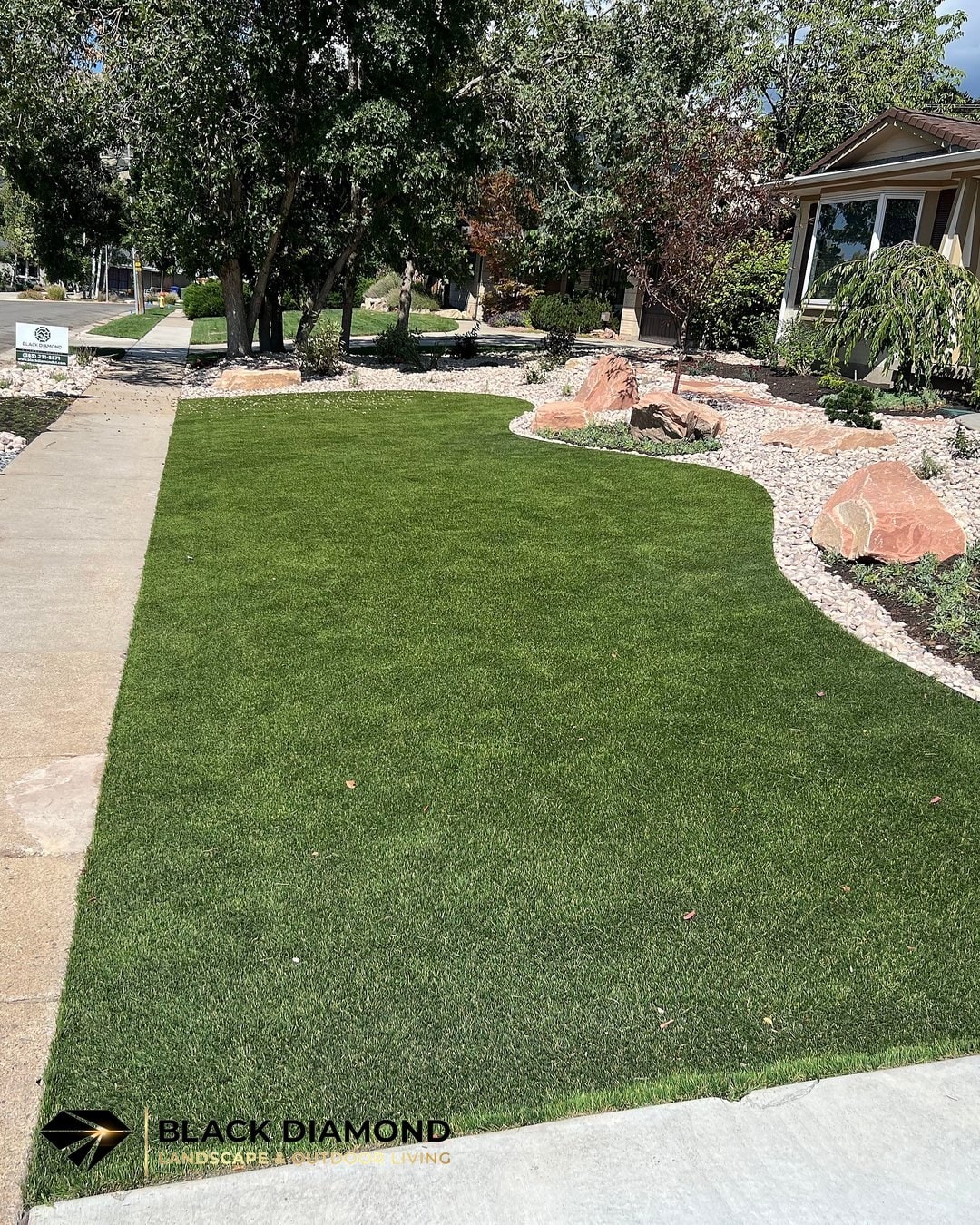 Emigration Canyon front yard — artificial turf with rock border and low-water planting, a turf conversion rebate-eligible project