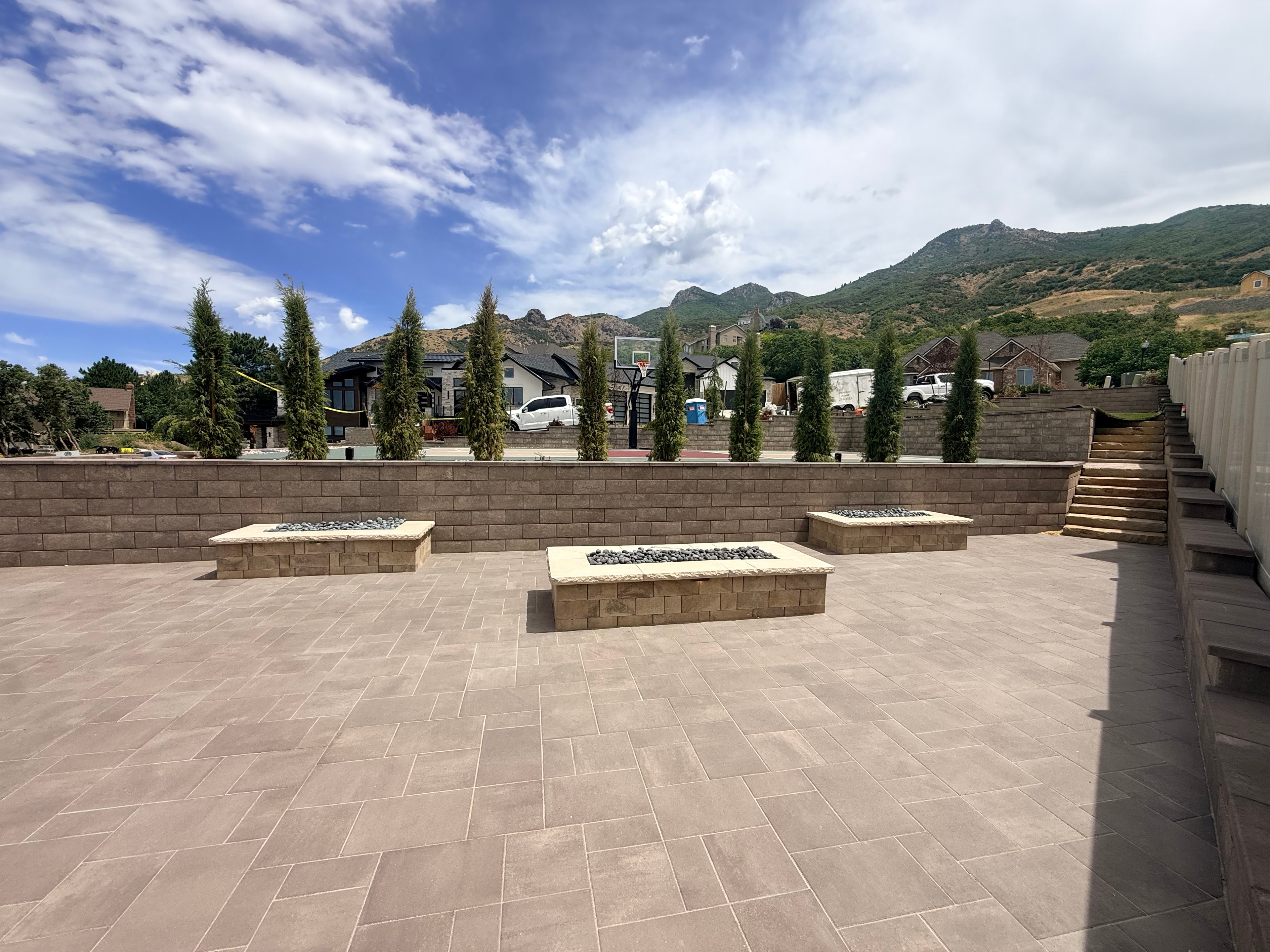 Complete outdoor living renovation in Layton, Utah — sport court, Belgard hardscapes, paver terrace and mountain backdrop