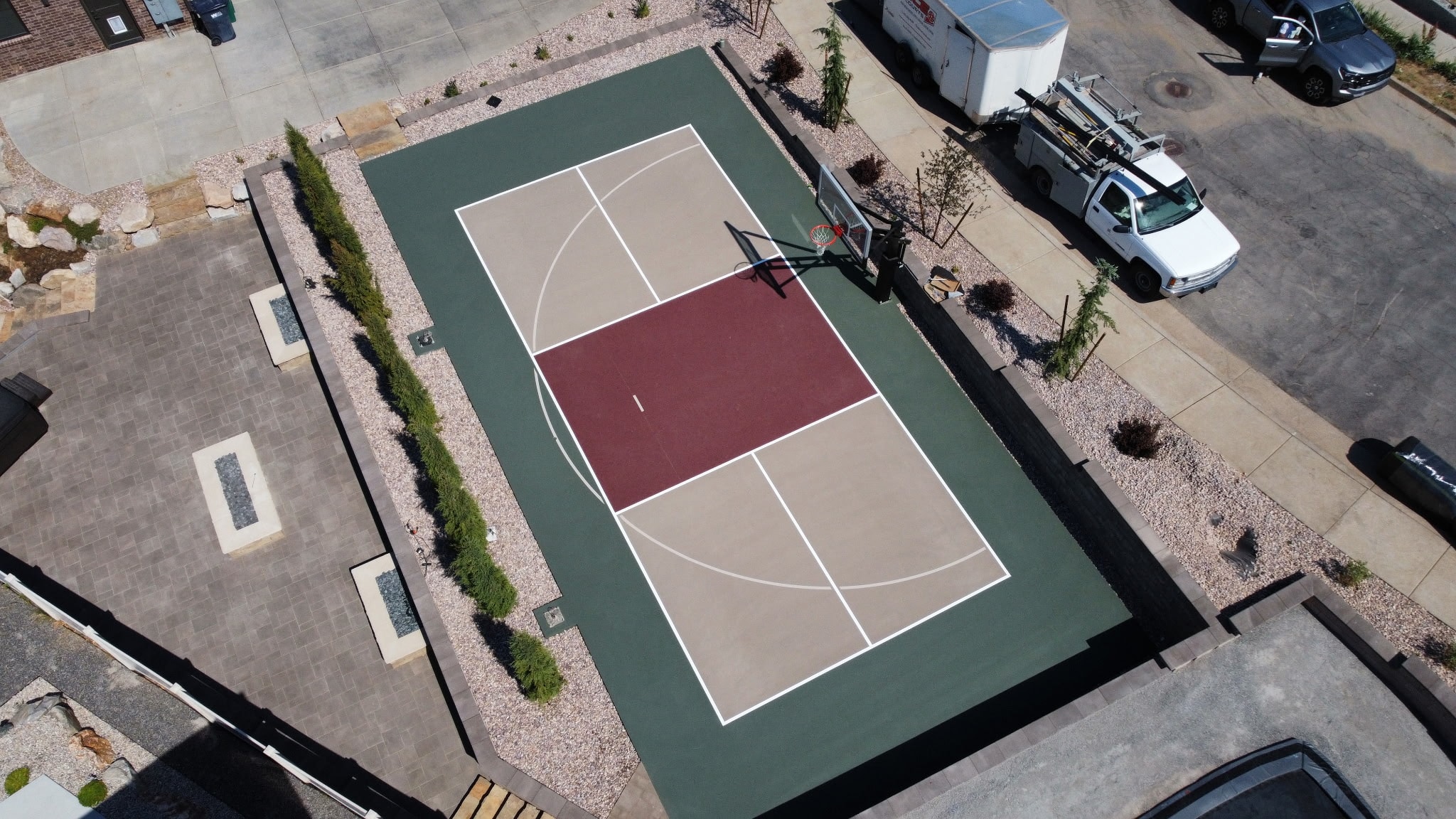 Aerial view of a custom residential sport court and adjacent outdoor living patio in Layton, Utah