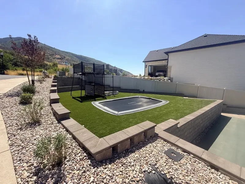 Springfree in-ground trampoline installed flush within an artificial turf recreation area in Layton, Utah