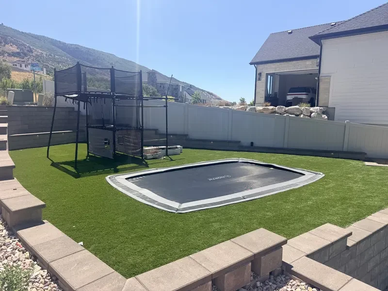Artificial turf recreation area and Springfree in-ground trampoline adjacent to the post-tension sport court in Layton, Utah