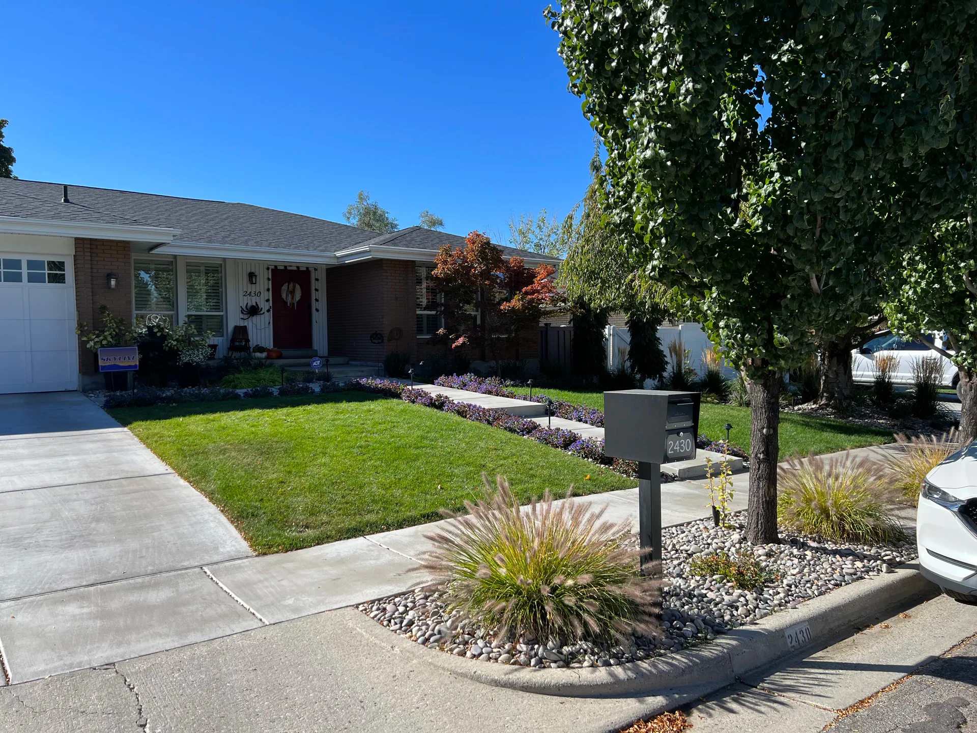 Millcreek front entry with a concrete walkway, BioGrass lawn, decorative stone and newly installed planting beds
