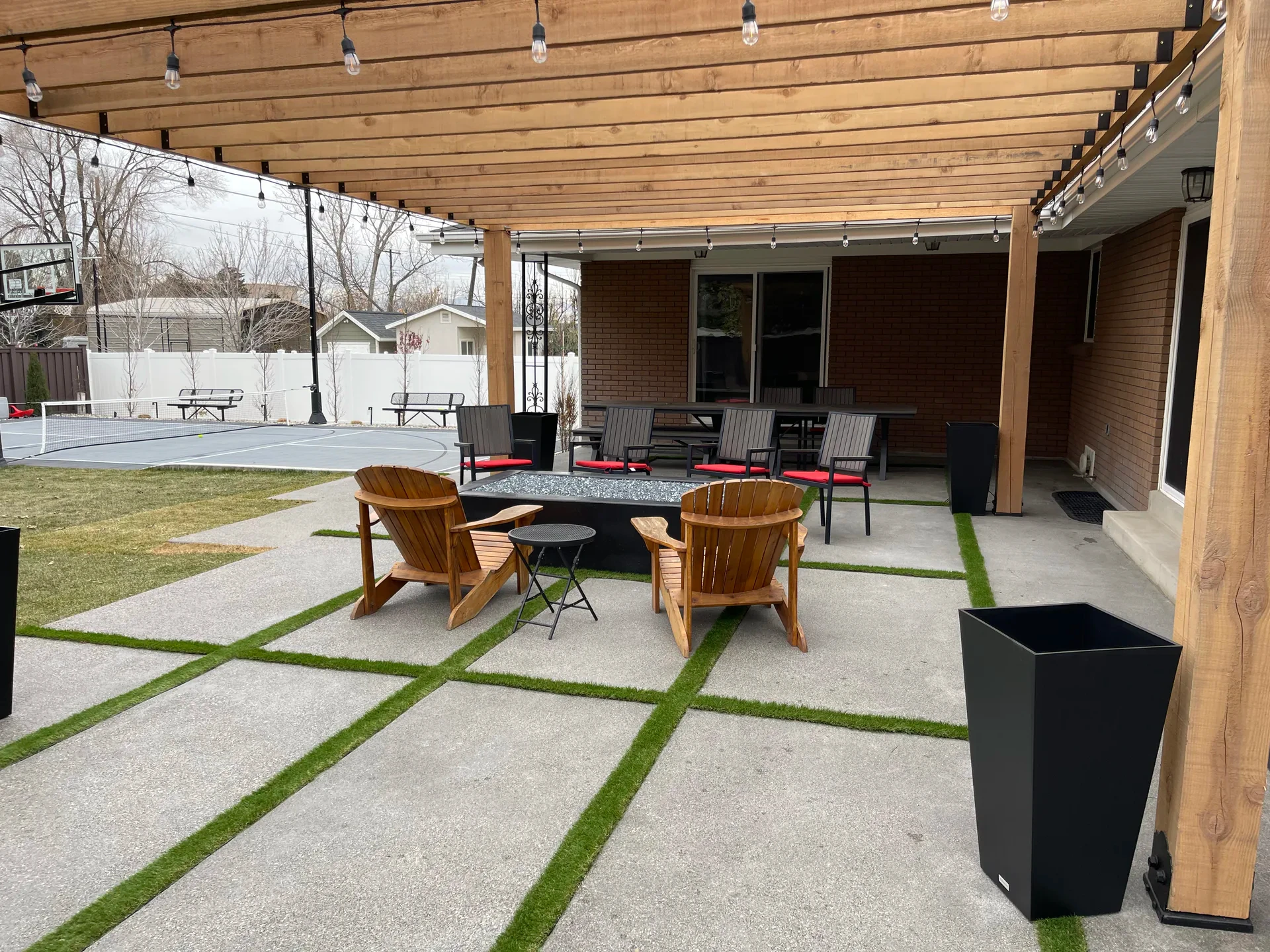 Open wood pergola over a custom concrete patio with turf joints and seating in Millcreek, Utah