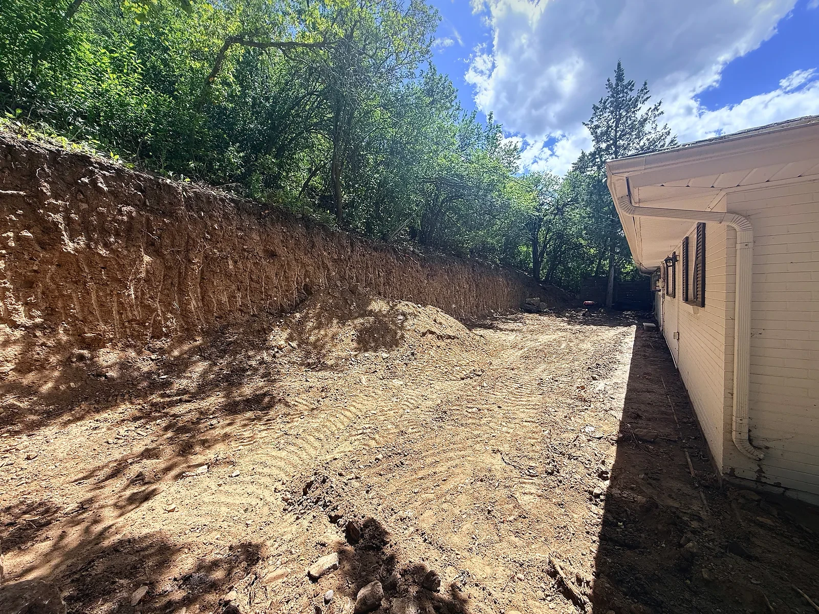 Backyard slope cut back and regraded after the old wall and concrete were removed