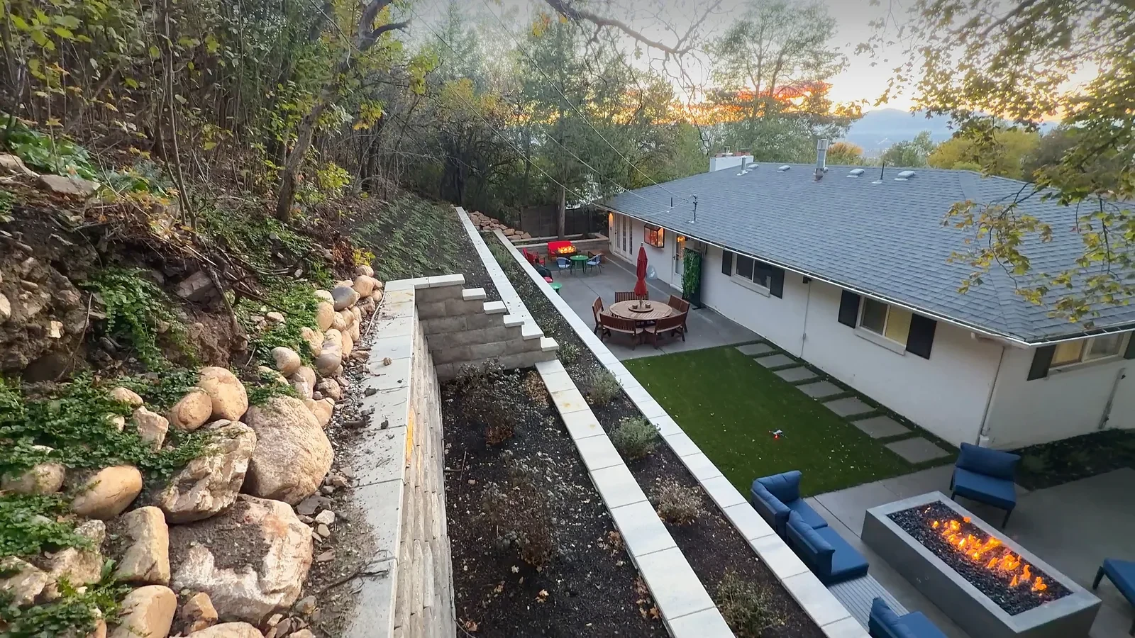 Terraced Belgard Diamond Pro retaining walls with block steps climbing an Olympus Cove hillside at sunset