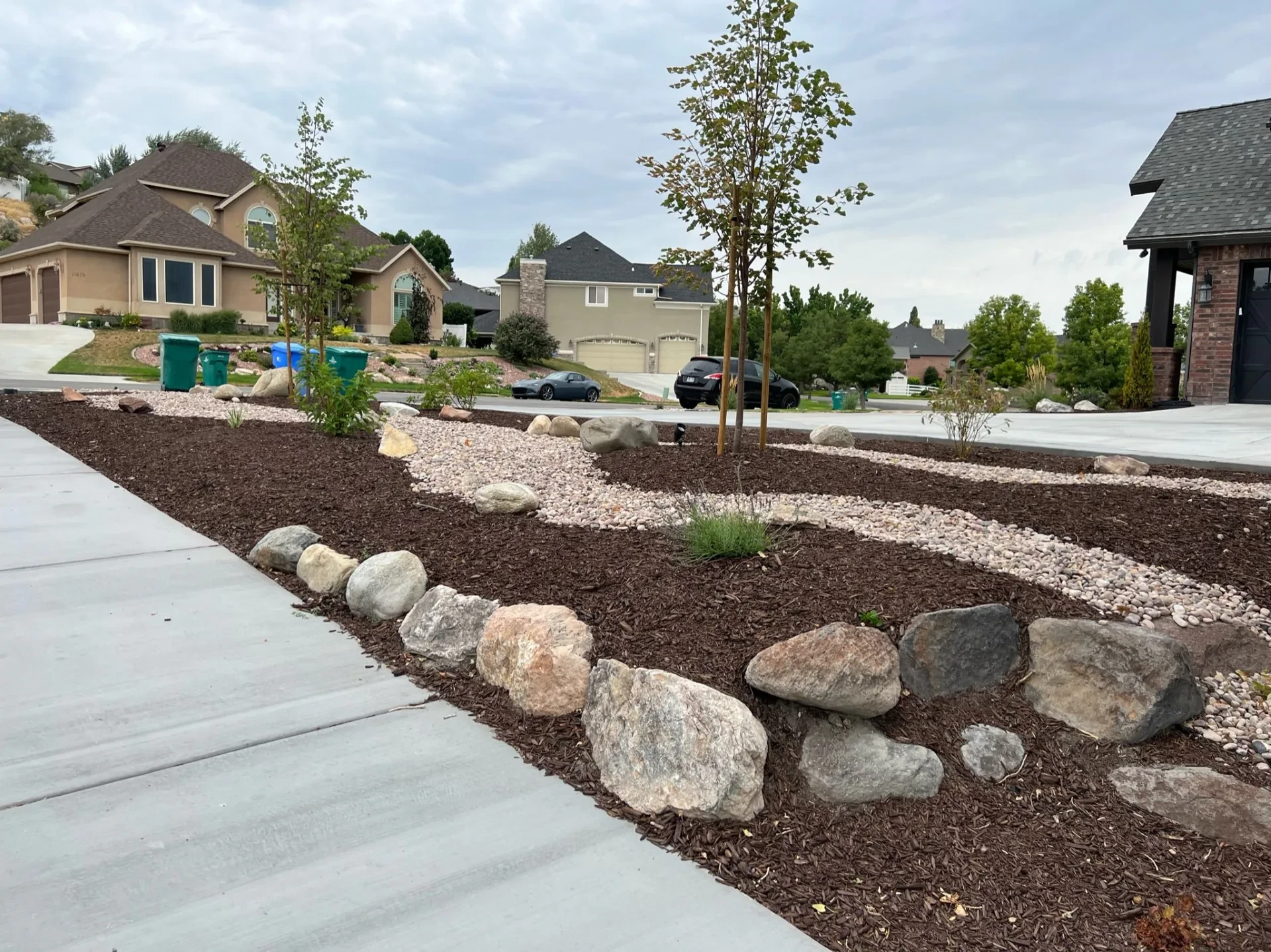 Completed Riverton, Utah backyard landscape renovation — Belgard patio, fire feature, waterfall, lawn, and planting.