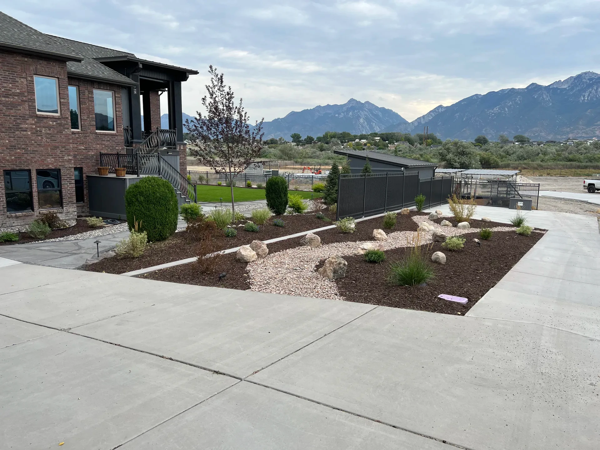 Decorative rock channel with planted beds and boulders in the finished landscape