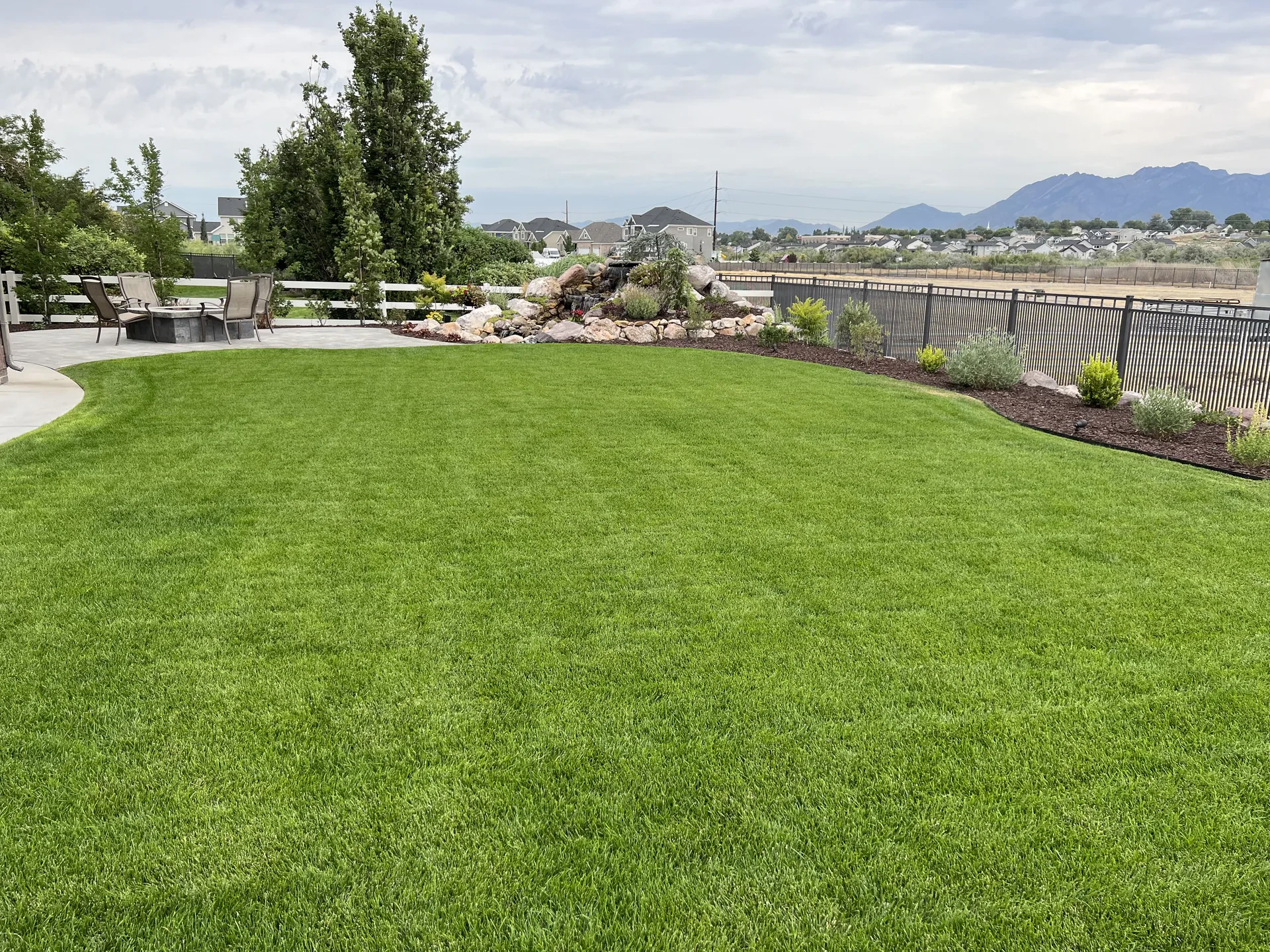 Spacious backyard lawn with mountain views and water feature