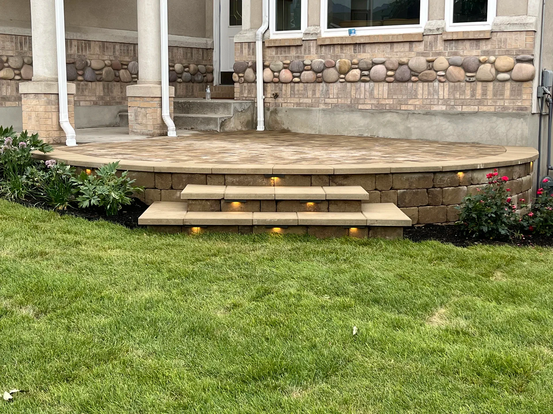 Belgard paver entry terrace with broad steps, new plantings, and warm step lighting in Sandy, Utah