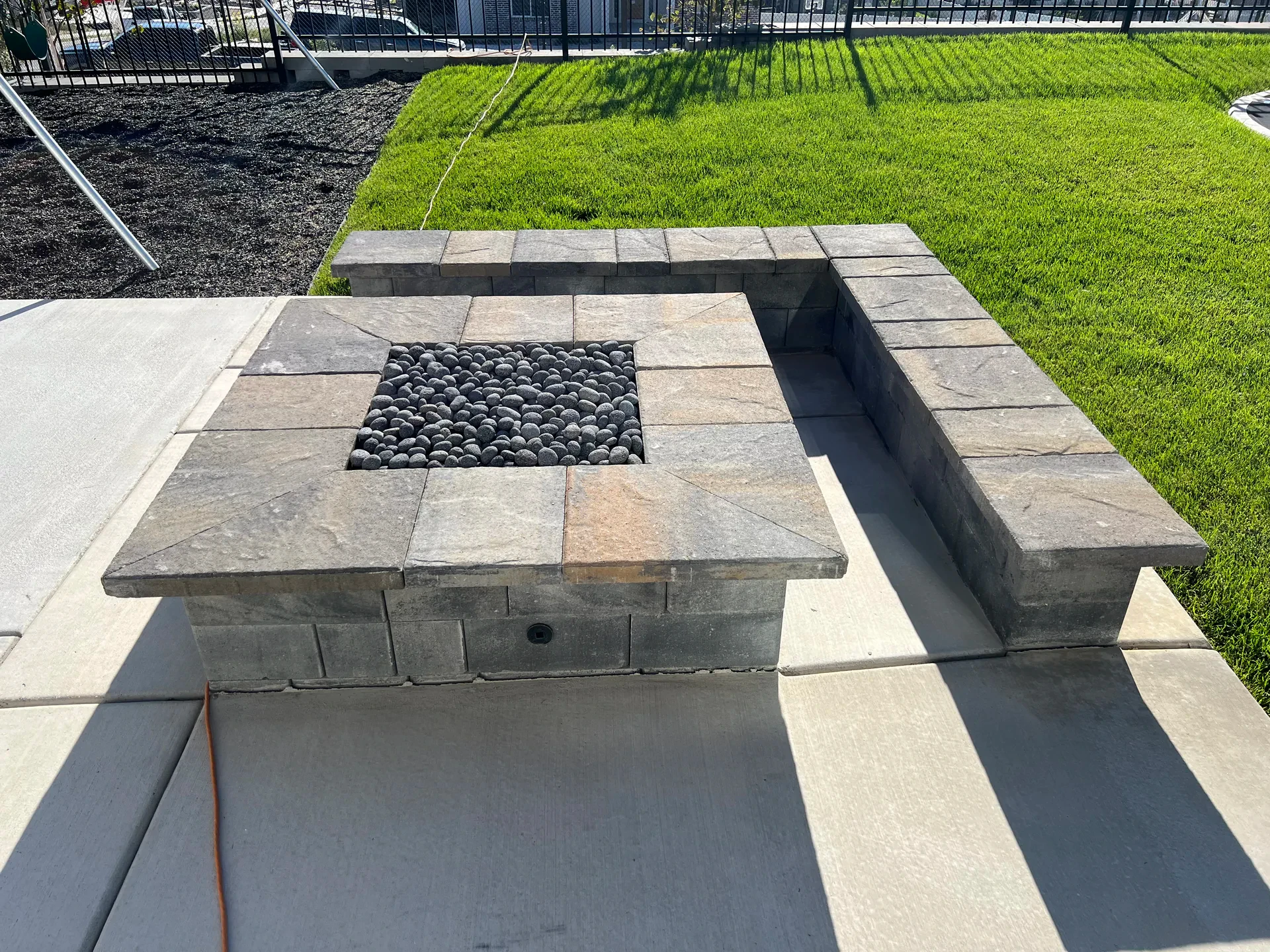 Custom fire feature with artificial turf and landscape patio in South Jordan, Utah.
