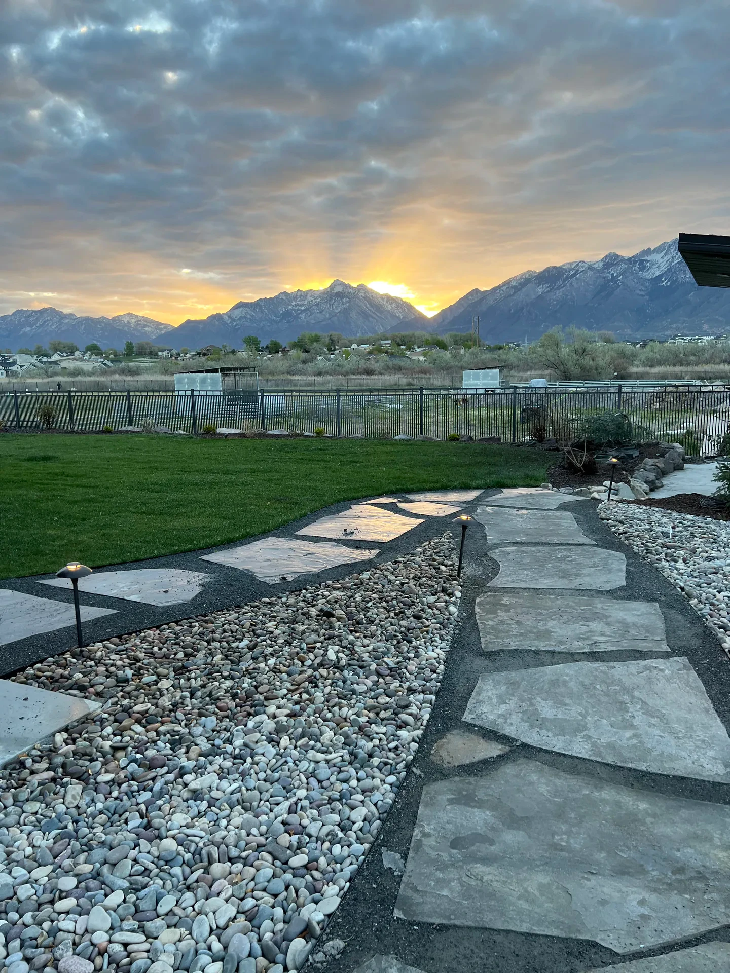 Natural stone pathway through decorative stone and turf at sunset in South Jordan, Utah.