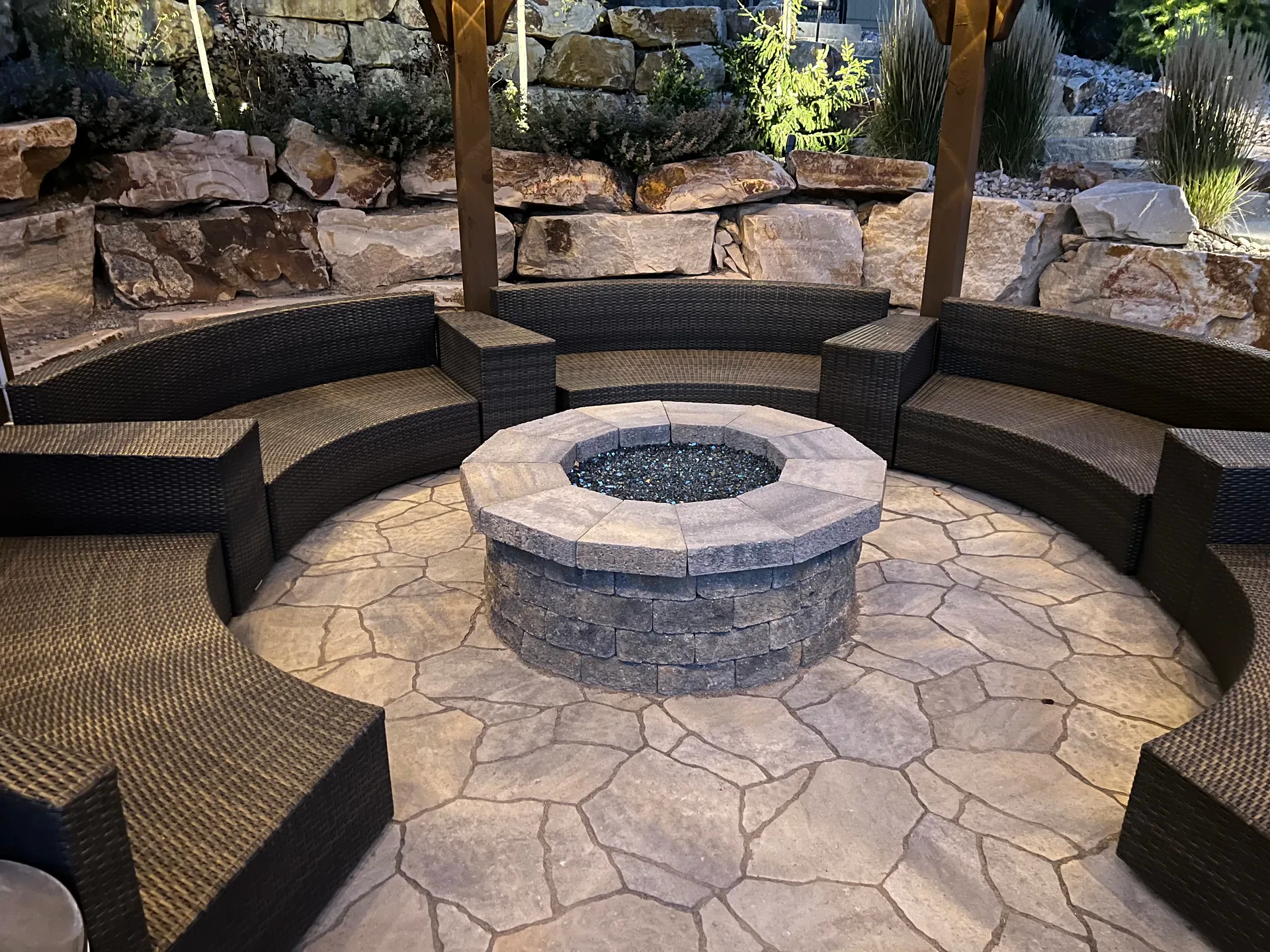 Circular fire feature with curved seating and pergola in Suncrest, Draper outdoor living area