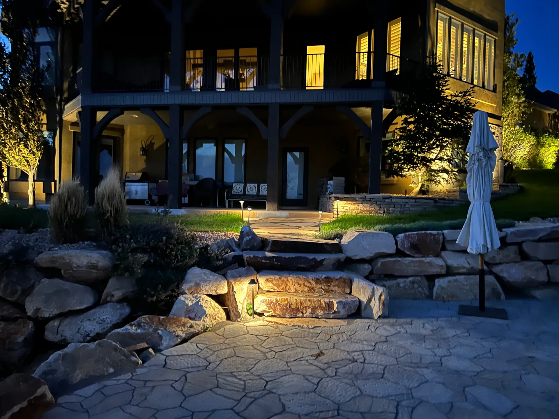 Illuminated pergola and hardscape patio at night in Suncrest, Draper Utah