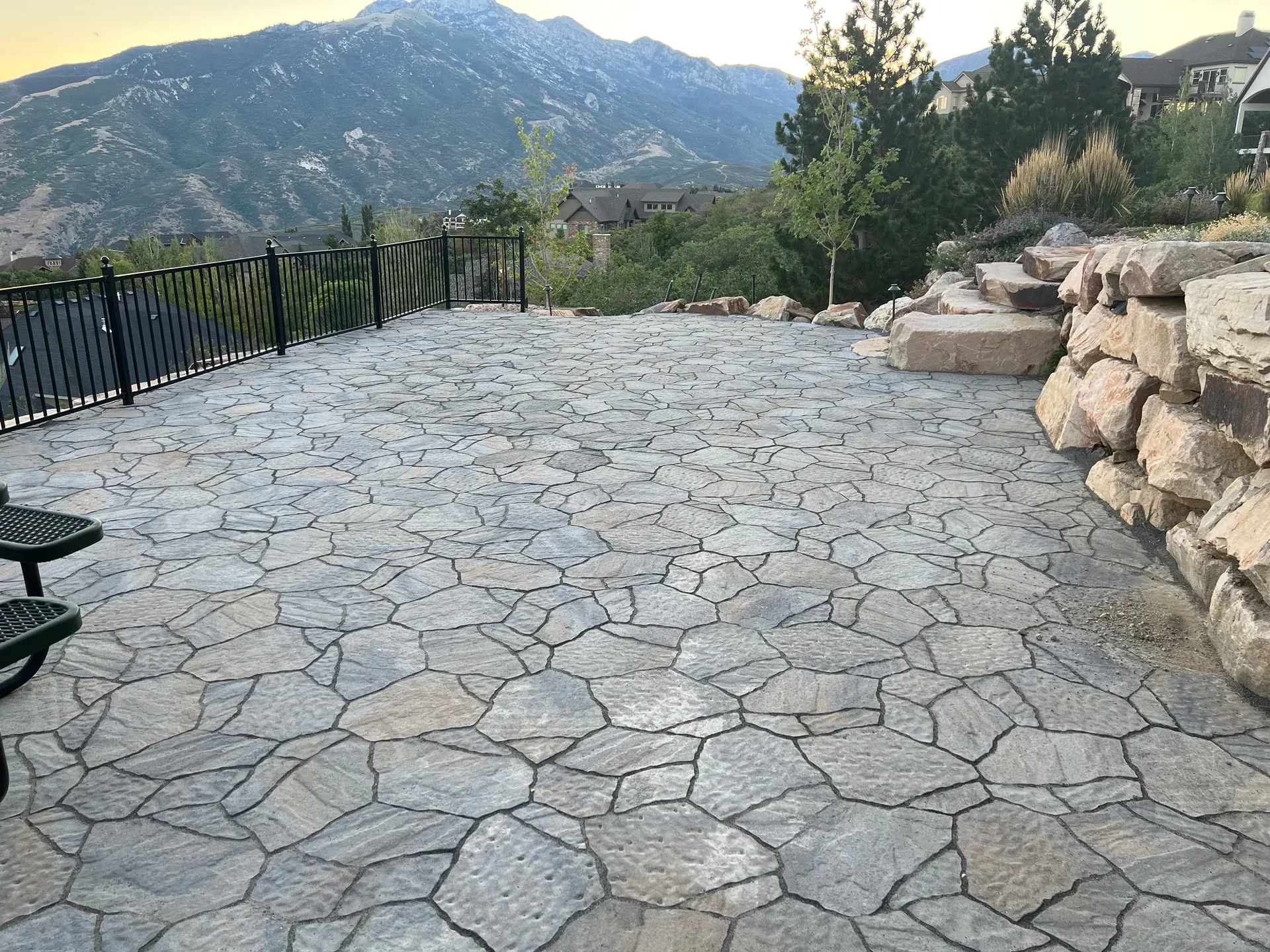 Patterned hardscape patio with natural stone walls overlooking the valley in Suncrest