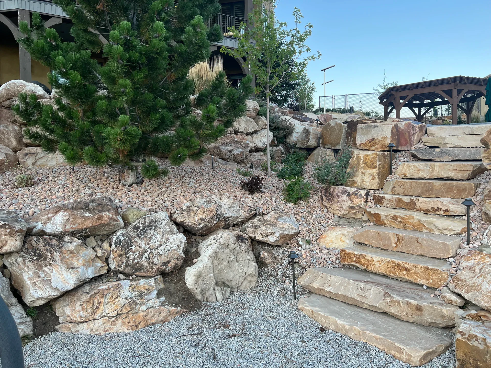 Natural slab-cut stone stairs leading to a custom pergola in Suncrest, Draper Utah