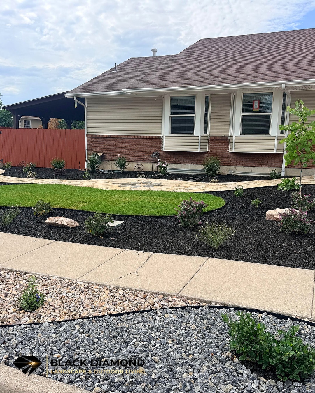 West Jordan front yard after renovation — flagstone walkway, planting beds, and water-wise rock strip