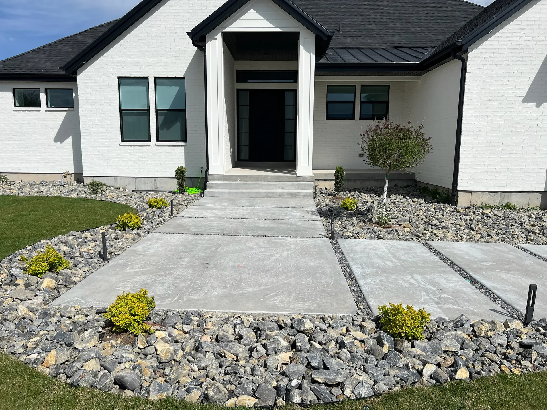 Concrete entry steps and wide walk panels with decorative-rock joints in West Valley City