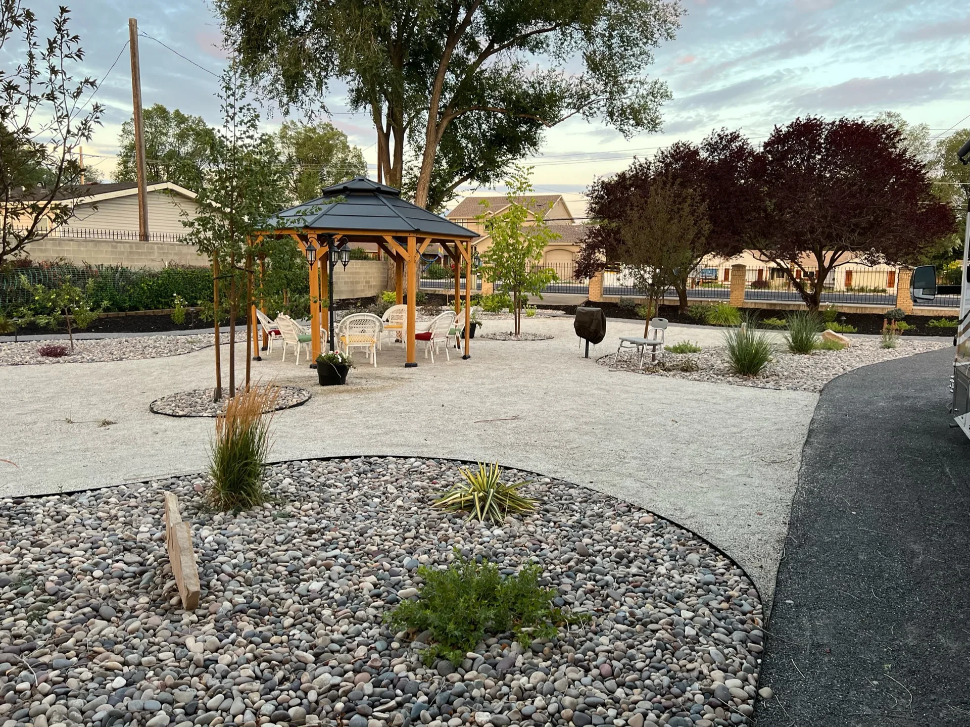 Pergola, decorative stone, drought-tolerant planting and curving paths in a West Valley City backyard garden