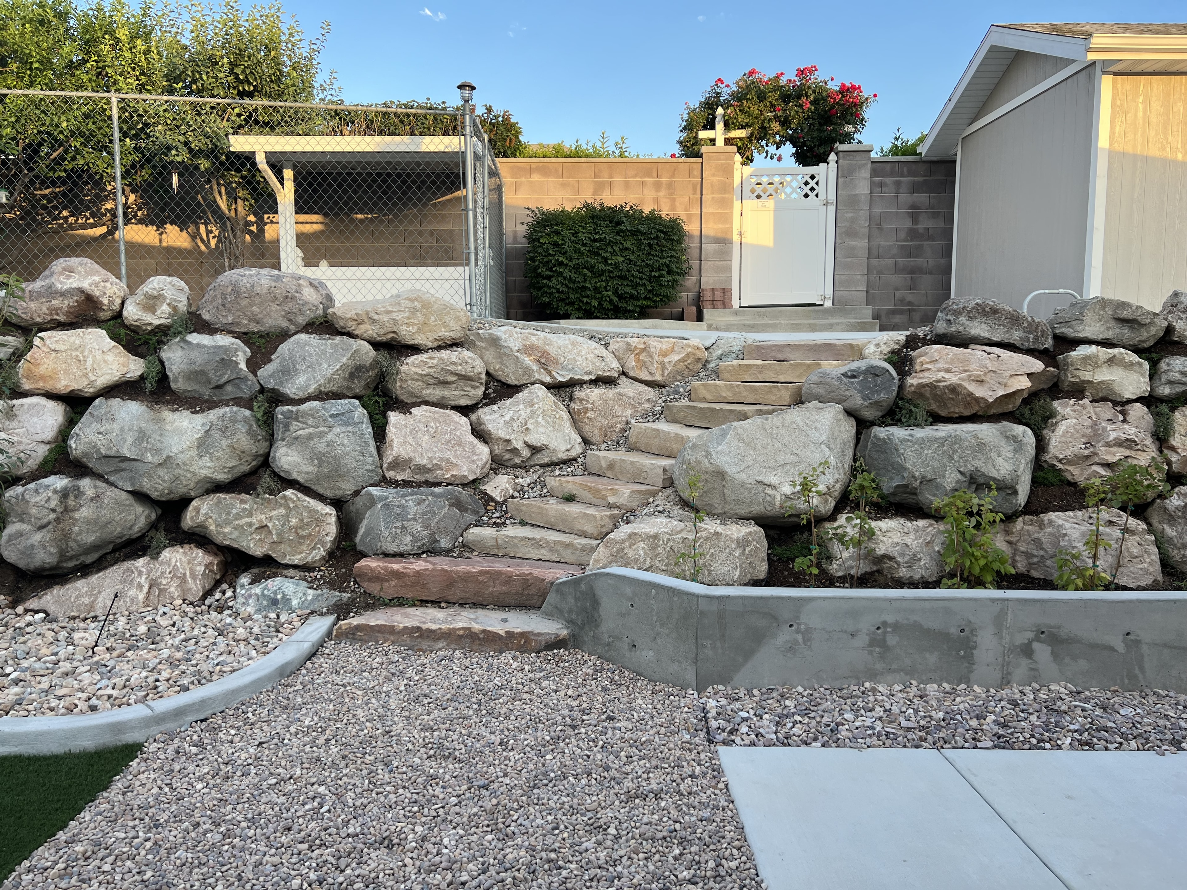 Stone retaining wall with backyard landscape design — Black Diamond project
