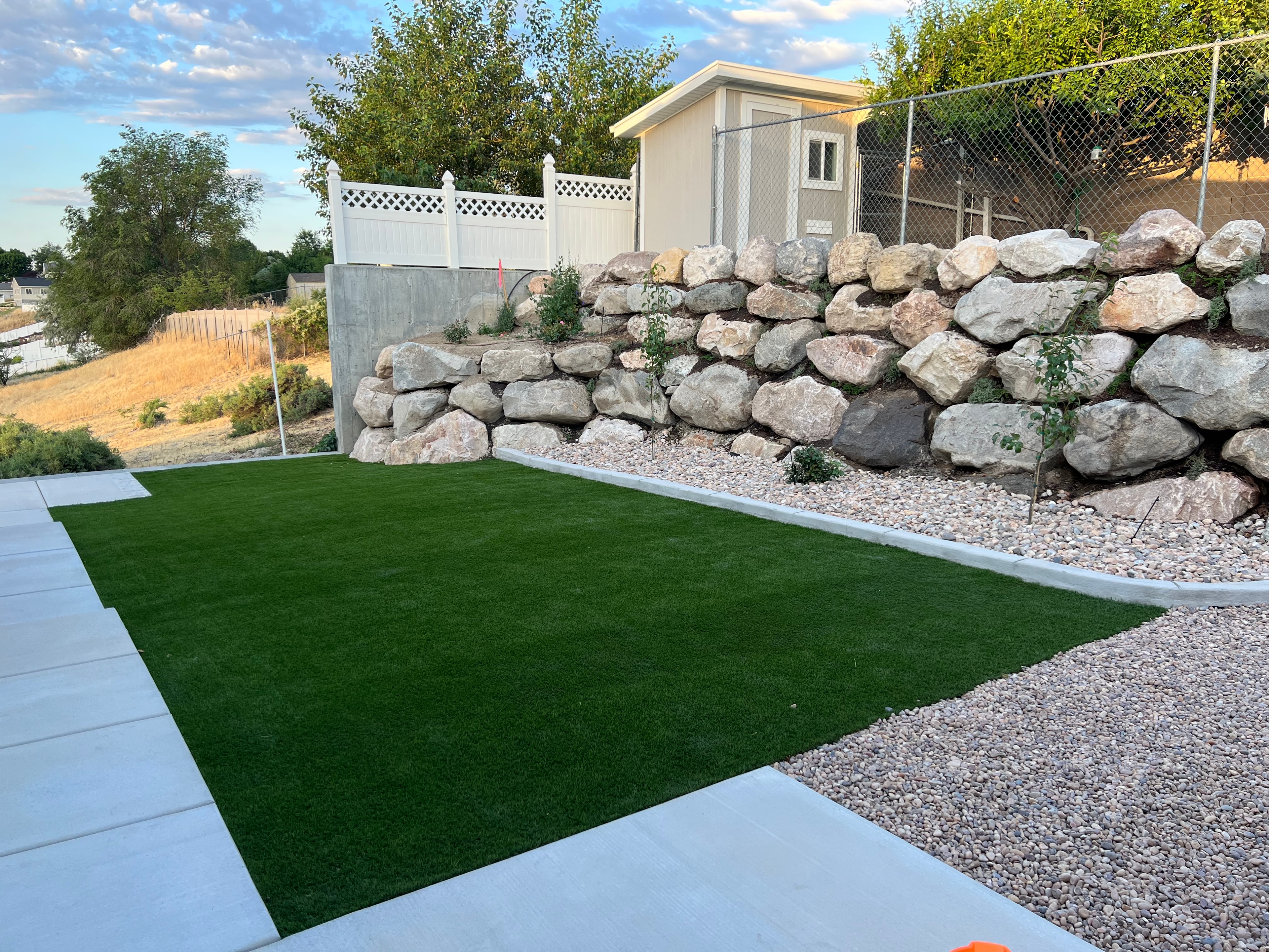 Backyard with artificial turf and stone retaining wall — Black Diamond project