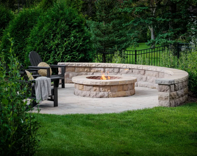 Belgard Dimensions 6 paver patio with curved Belair Wall seat wall and fire pit — manufacturer inspiration.