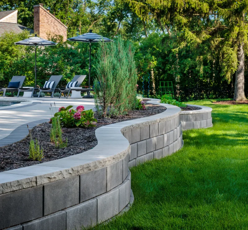 Belgard Diamond Pro Smooth Face curved retaining and seat walls with raised planting beds and pool — manufacturer inspiration.